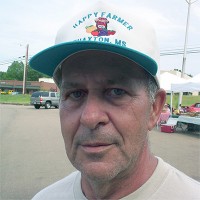 Chas Laughlin Man with gray hair and five o'clock shadow in a trucker hat